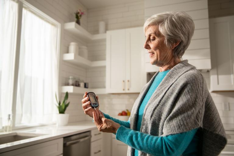 Woman taking blood glucose reading with Accu-Chek Guide meter